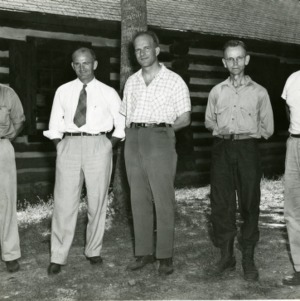 Five men in front of log house