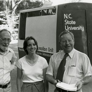 Three people standing in front of N.C. State University recreation unit