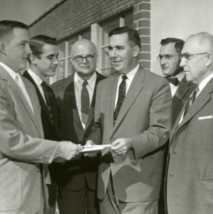 Six men exchanging papers