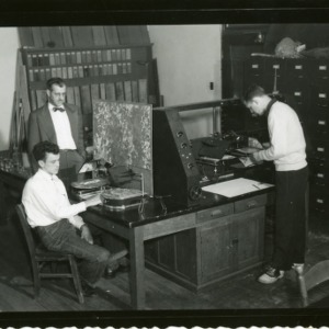 Three men at desk