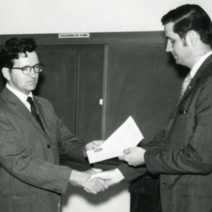 Two men shaking hands at Student Chapter of TAPPI meeting
