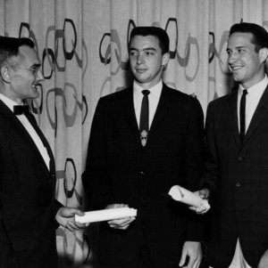 Three men with certificates