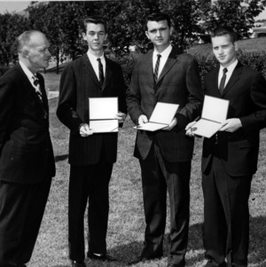 Four men with certificates