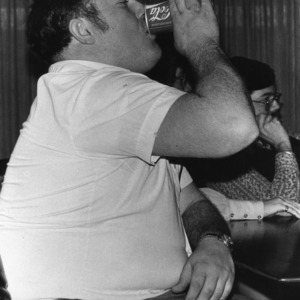 Portrait of student body president Donald Abernathy drinking a Coke at a counter