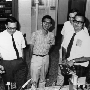 Larry K. Monteith and engineering group examining four channel communication system