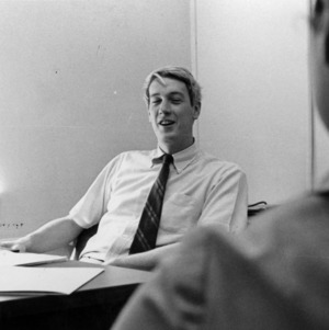 John Poole at desk with other