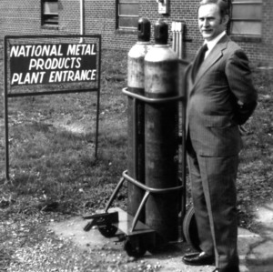 Man and machine at National Metal Products Plant Entrance