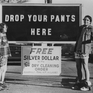 Two students promoting dry cleaners' by dropping their pants