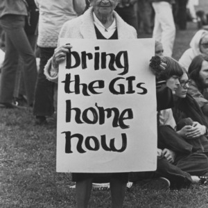 Older woman at anti-war demonstration with sign "Bring the GIs home now"