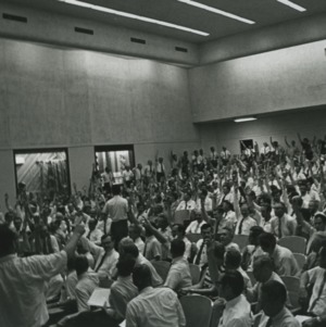 Group raising hands in auditorium