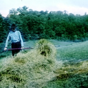 Man and a stack of hay in a hilly region