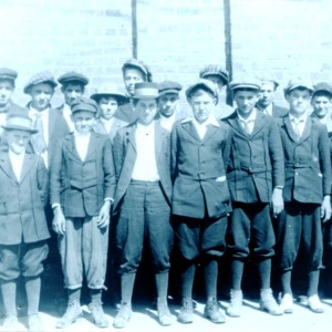 Group of twenty-one boys in front of brick building