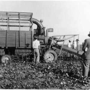 Men operating farm machinery