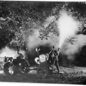 Orchard dusting at night with tractor operated equipment