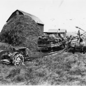 Small McCormick-Deering Thresher Powered by Farmall Tractor