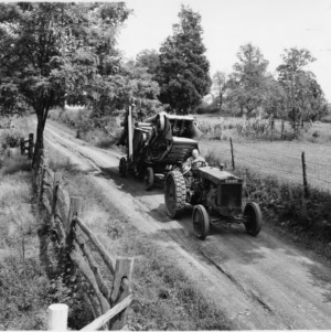 Man on tractor with thresher