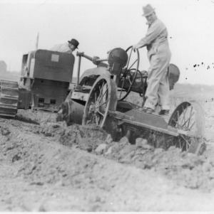Men on Caterpillar tractor and agricultural machinery