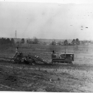 Two men on tractor and agricultural machinery