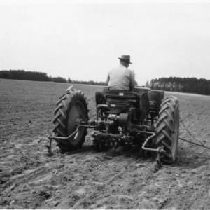 Man planting cotton with two-row planter with fork attachment and row marker