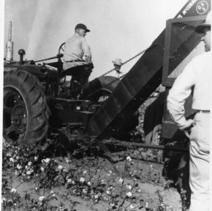 Men with agricultural machinery in cotton field
