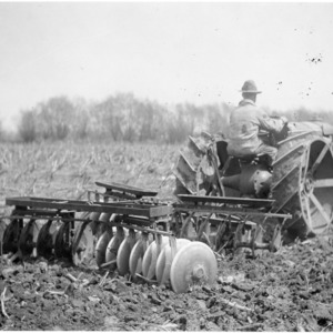 Man operating tractor and automatic tractor discs