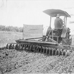 Man operating tractor and Roderick Lean automatic tractor discs