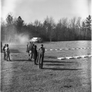 Men observing fertilizer spreader calibration