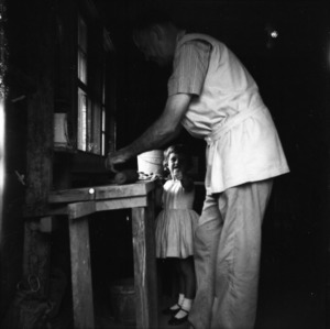 Potter Ben Owen Sr. at pottery wheel with young girl