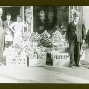 Group outside store with fruit displays, circa 1910