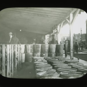 Men and pack produce outside depot, circa 1900