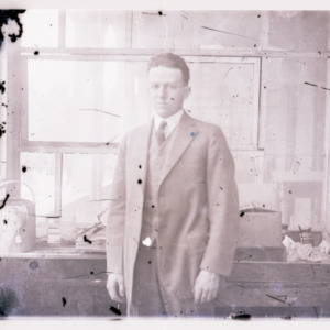 Man in front of equipment, undated