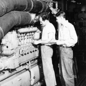 Two researchers adjusting fuel pump on American Locomotive 539-Type diesel engine