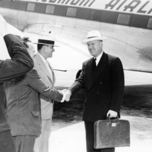 US Secretary of Agriculture Charles F. Brannan, Jonathan Daniels, and Governor W. Kerr Scott meeting at airport