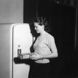 Girl putting eggs in refrigerator