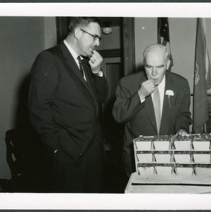 Jim Graham, general manager of the Raleigh Farmers Market, and Governor Luther Hodges tasting from a crate of strawberries