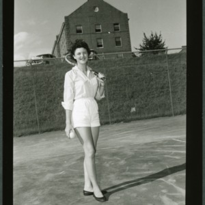 4-H club member Lois Immons playing tennis while attending North Carolina State 4-H Club Week
