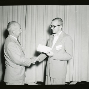 Robert C. Bealer receiving check from Dr. Joseph G. Knapp at American Institute of Cooperation
