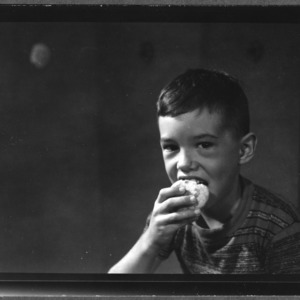 Young boy eating corn muffin