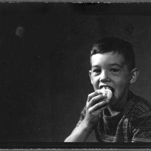 Young boy eating corn muffin