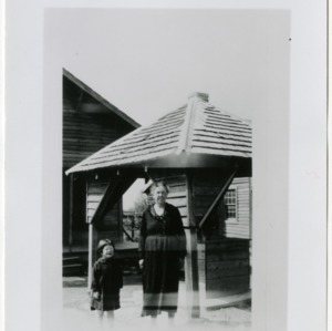 Bespectacled older woman and little girl standing outside