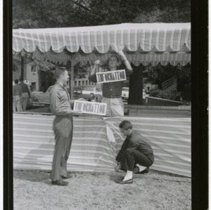 1959 Engineers Fair: Information Booth, inertia car, and girl standing in pipe