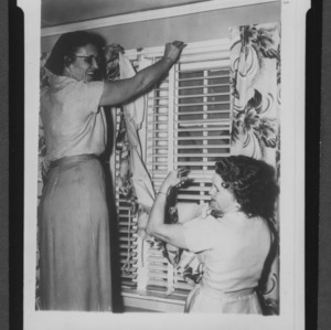 Wilmington Home Demonstration club members hanging curtains