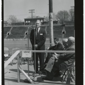 John Caldwell speaking in front of a sports field