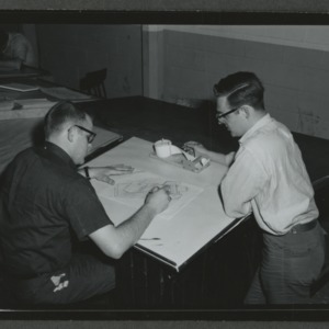 Two men at drafting table