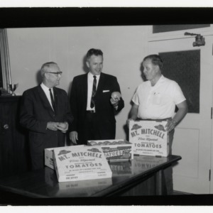 George Conrad presenting tomatoes to Director Shoffner