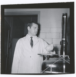 W. L. Payne conducting poultry research with chick
