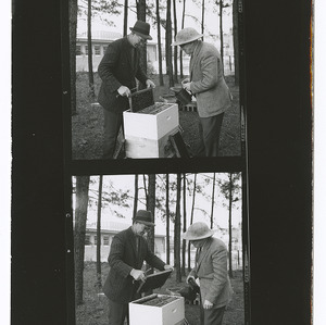 Dr. W. A. Stephens and Phil Bishop with beehive in Canada