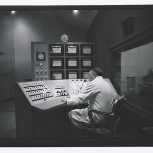 Engineer at control panel in atomic reactor building