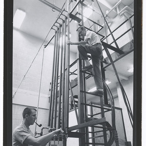 Two men adjusting engineering research lab equipment
